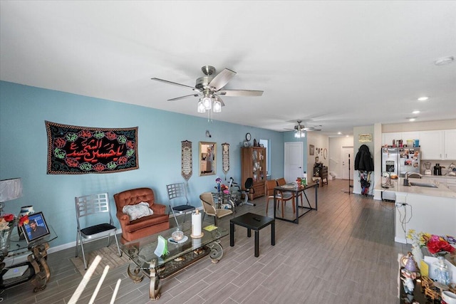 living room with ceiling fan, sink, and light hardwood / wood-style flooring