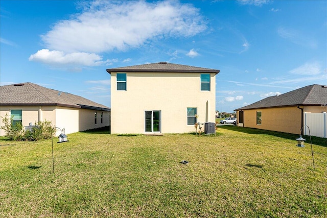 back of property with a lawn and central air condition unit