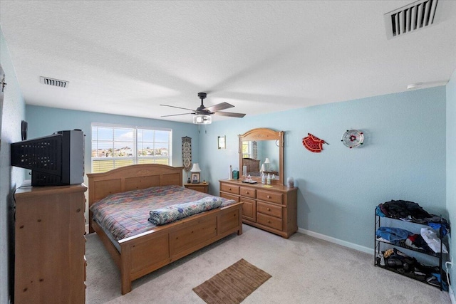 carpeted bedroom with a textured ceiling and ceiling fan