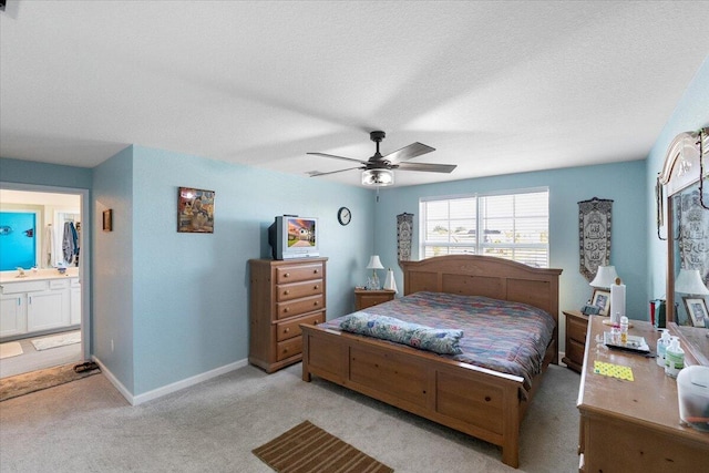 carpeted bedroom featuring ceiling fan and ensuite bath