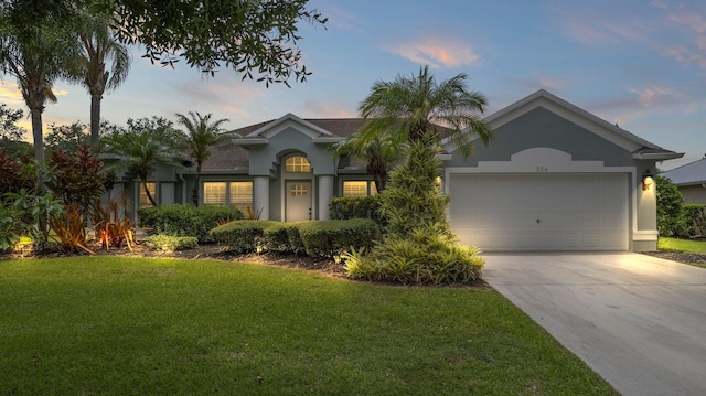 view of front of house with a yard and a garage