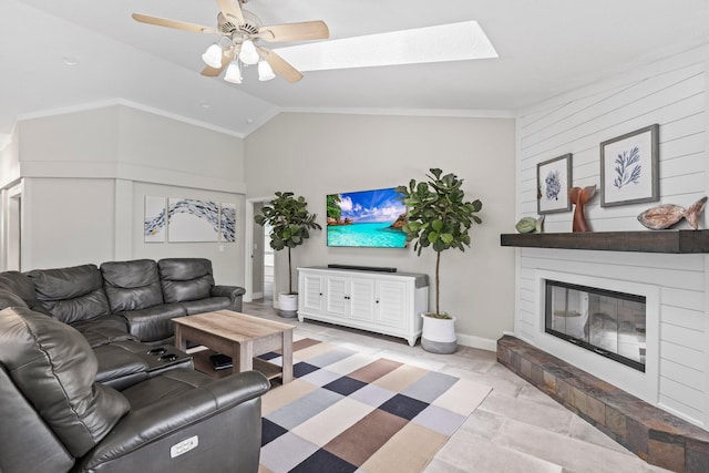 living room with ceiling fan, lofted ceiling with skylight, and a fireplace