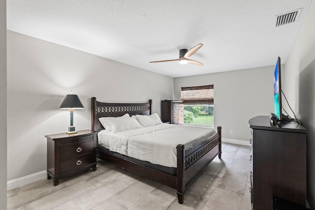 bedroom with ceiling fan and a textured ceiling