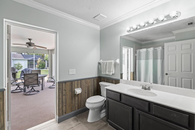 bathroom featuring vanity, a textured ceiling, ceiling fan, crown molding, and wood walls