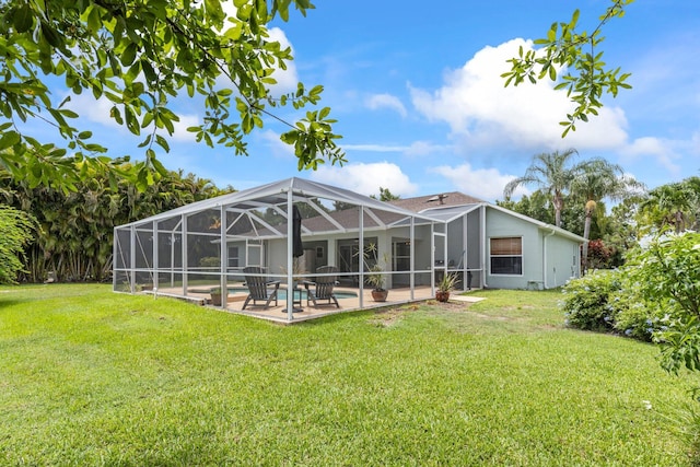 rear view of property with a patio area, a lanai, a yard, and a pool