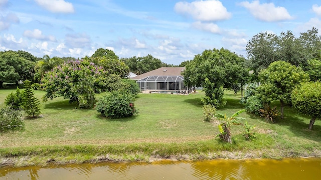 view of yard with a water view and glass enclosure