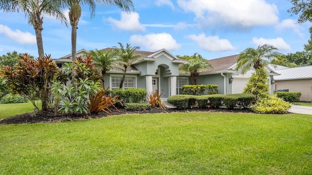 view of front of home with a front yard and a garage