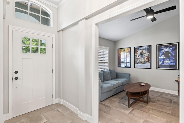 foyer entrance with ceiling fan, lofted ceiling, and a textured ceiling