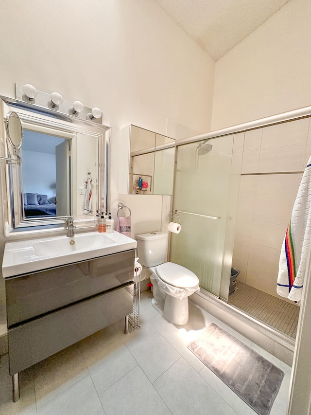 bathroom featuring a tile shower, vanity, a textured ceiling, tile patterned flooring, and toilet