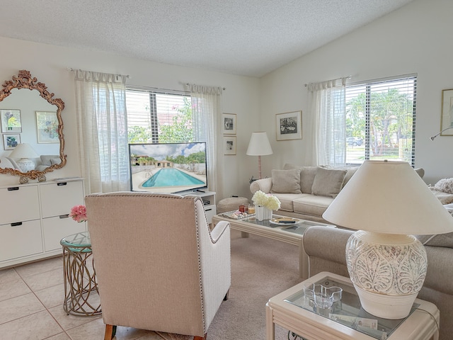 living room with vaulted ceiling, light tile patterned flooring, a healthy amount of sunlight, and a textured ceiling