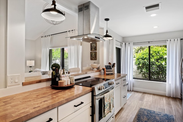 kitchen featuring stainless steel electric range, wooden counters, hanging light fixtures, white cabinetry, and island exhaust hood