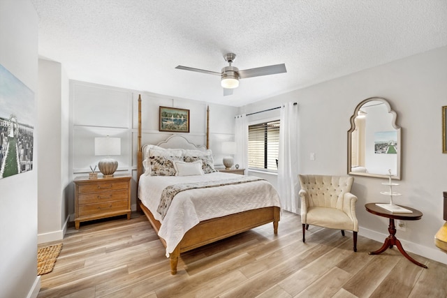 bedroom with ceiling fan, light wood-type flooring, and a textured ceiling