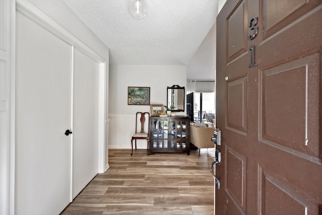 entrance foyer featuring a textured ceiling and light hardwood / wood-style flooring