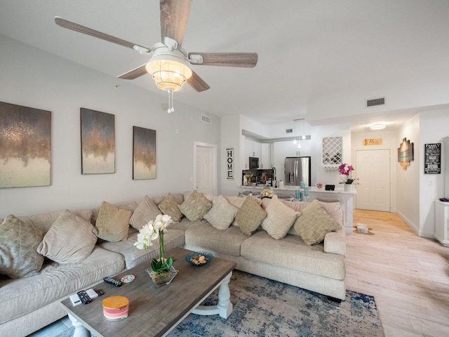 living room with ceiling fan and light wood-type flooring