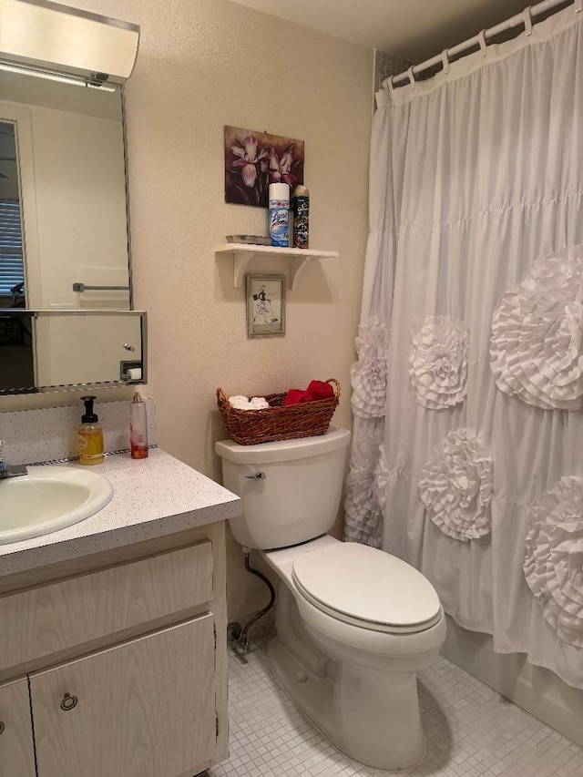 full bathroom with tile patterned flooring, vanity, toilet, and shower / bath combo with shower curtain