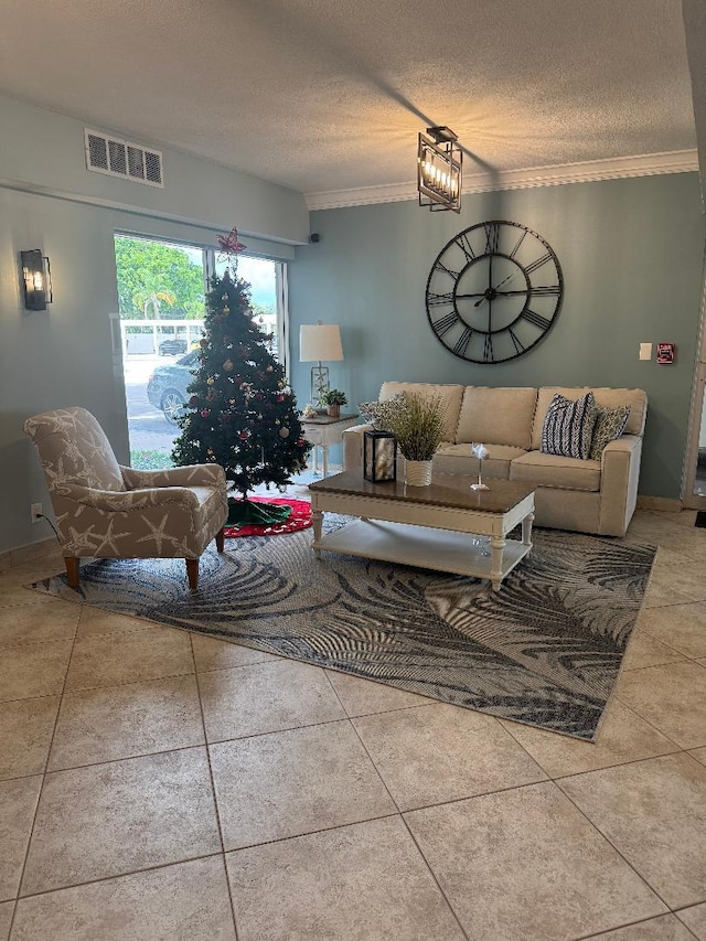 living room featuring light tile patterned floors, ornamental molding, a textured ceiling, and a notable chandelier