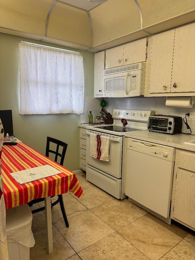 kitchen with white appliances and light tile patterned flooring