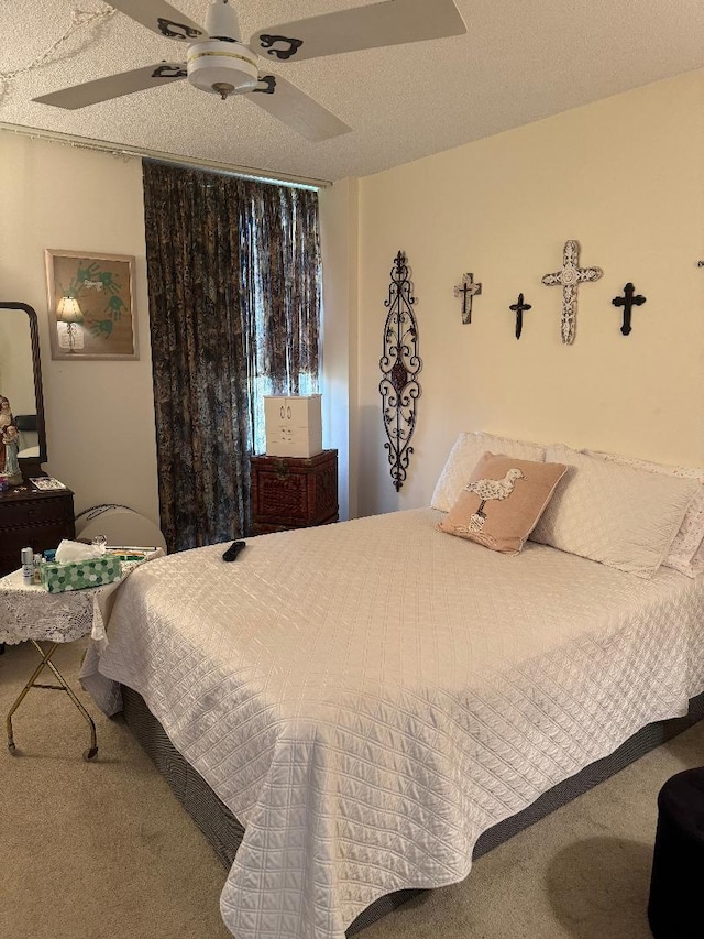 bedroom featuring carpet flooring, ceiling fan, and a textured ceiling