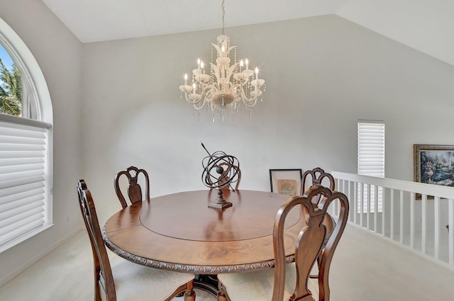 dining space with carpet, lofted ceiling, and an inviting chandelier