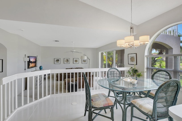 tiled dining area featuring ceiling fan with notable chandelier and vaulted ceiling