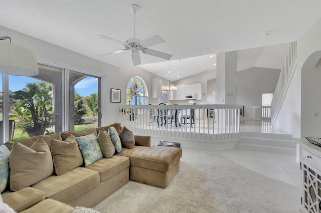 living room with ceiling fan, light tile patterned flooring, lofted ceiling, and a textured ceiling