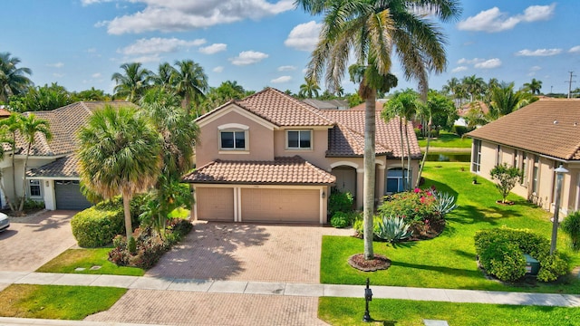 mediterranean / spanish house with a front yard and a garage