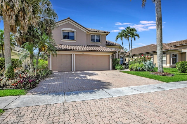 mediterranean / spanish home with a front yard and a garage