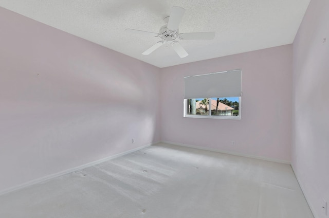 empty room with ceiling fan, a textured ceiling, and light carpet