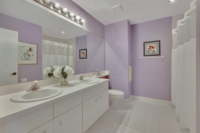 bathroom featuring tile patterned flooring, vanity, and toilet