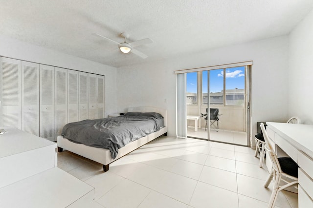 bedroom featuring ceiling fan, a closet, light tile patterned floors, and a textured ceiling