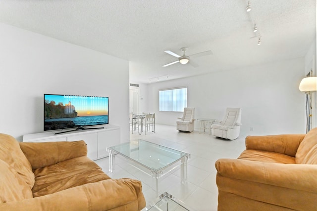 tiled living room with a textured ceiling, track lighting, and ceiling fan