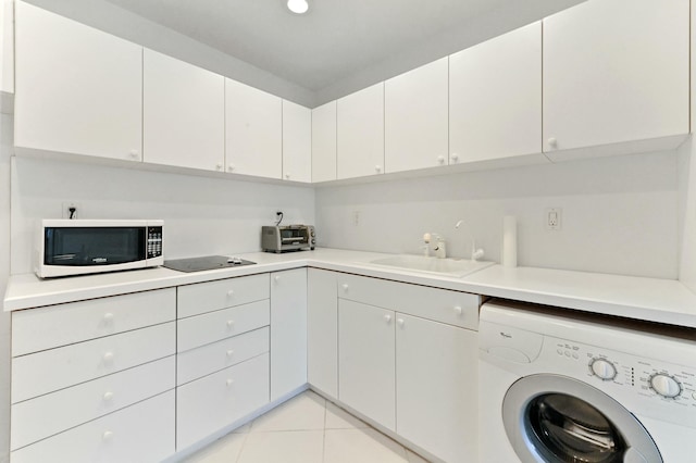 kitchen with washer / clothes dryer, white cabinetry, sink, and black electric cooktop