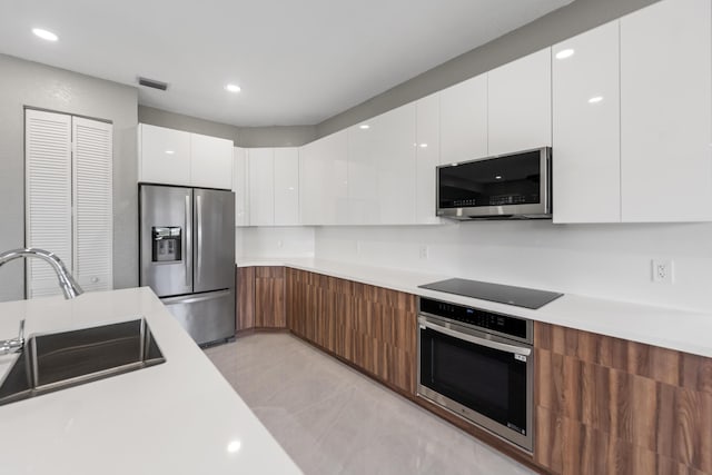 kitchen featuring sink, white cabinets, and appliances with stainless steel finishes