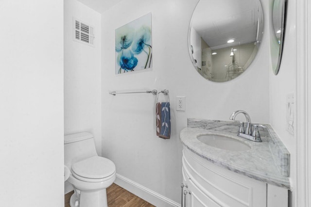 bathroom with vanity, toilet, and wood-type flooring