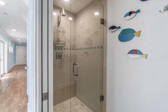 bathroom with hardwood / wood-style floors, an enclosed shower, and ornamental molding