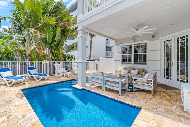 view of swimming pool with an outdoor living space, ceiling fan, and a patio area