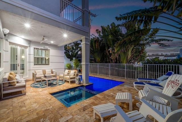 pool at dusk with outdoor lounge area, french doors, ceiling fan, an in ground hot tub, and a patio area