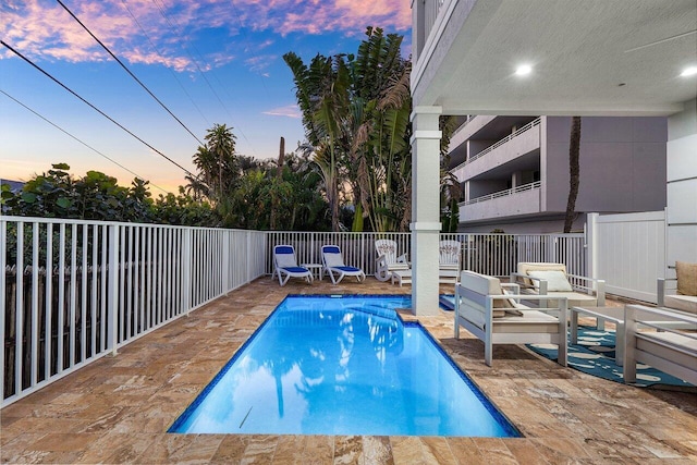 pool at dusk with a patio