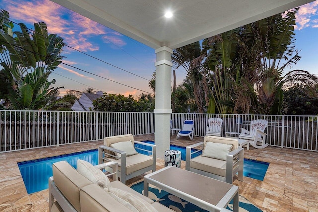 patio terrace at dusk with an outdoor hangout area and a fenced in pool