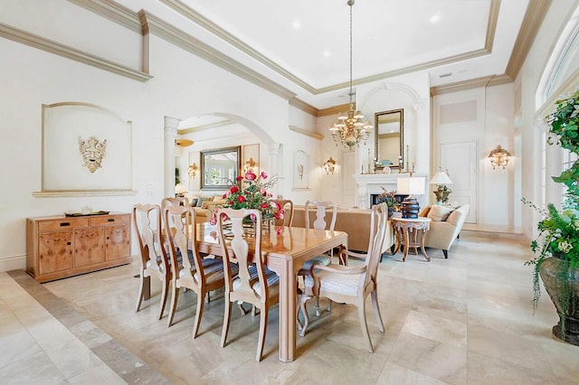 dining space featuring a notable chandelier, a raised ceiling, ornamental molding, and a high ceiling