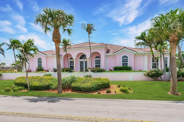 mediterranean / spanish home with a front yard