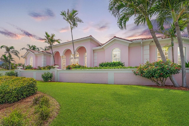 mediterranean / spanish-style home with a yard