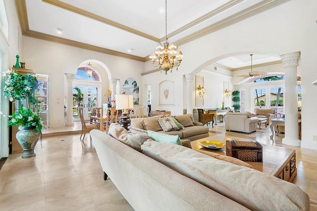 living room featuring ornate columns, french doors, a towering ceiling, ceiling fan with notable chandelier, and ornamental molding