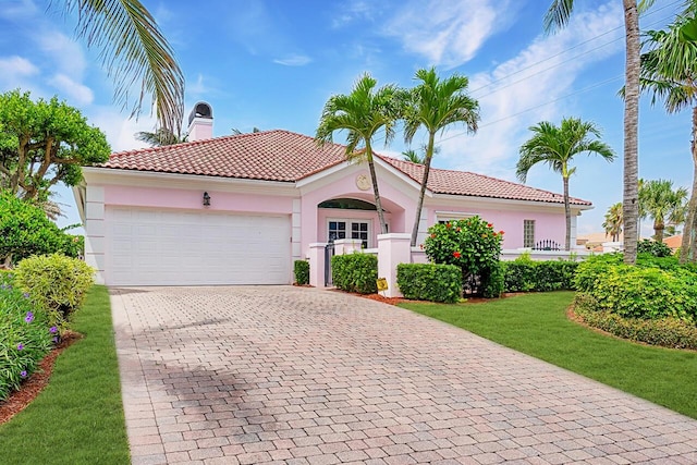 mediterranean / spanish house with a front yard and a garage