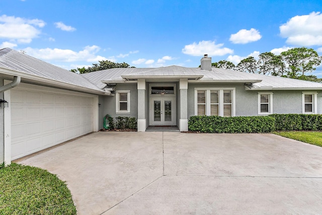 view of front of home with a garage and french doors