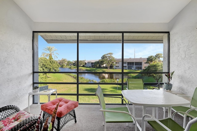 sunroom / solarium featuring a water view