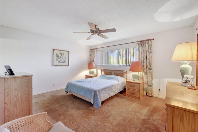 bedroom with ceiling fan, light carpet, and a textured ceiling