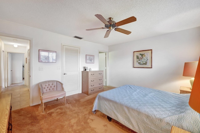 carpeted bedroom with a textured ceiling and ceiling fan