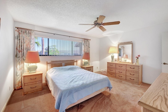 bedroom featuring ceiling fan, light colored carpet, and a textured ceiling