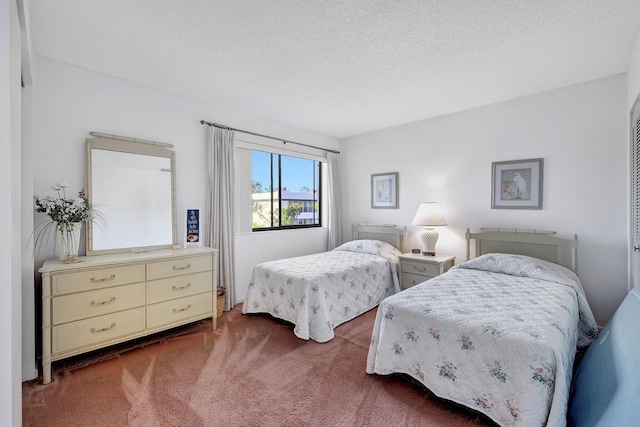 bedroom with a textured ceiling and dark carpet